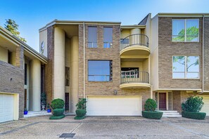 A multi-story residential building with a central courtyard, a garage, and a balcony on the upper floor. - < 2 Mi to Galleria: Spacious Houston Home! (Houston)