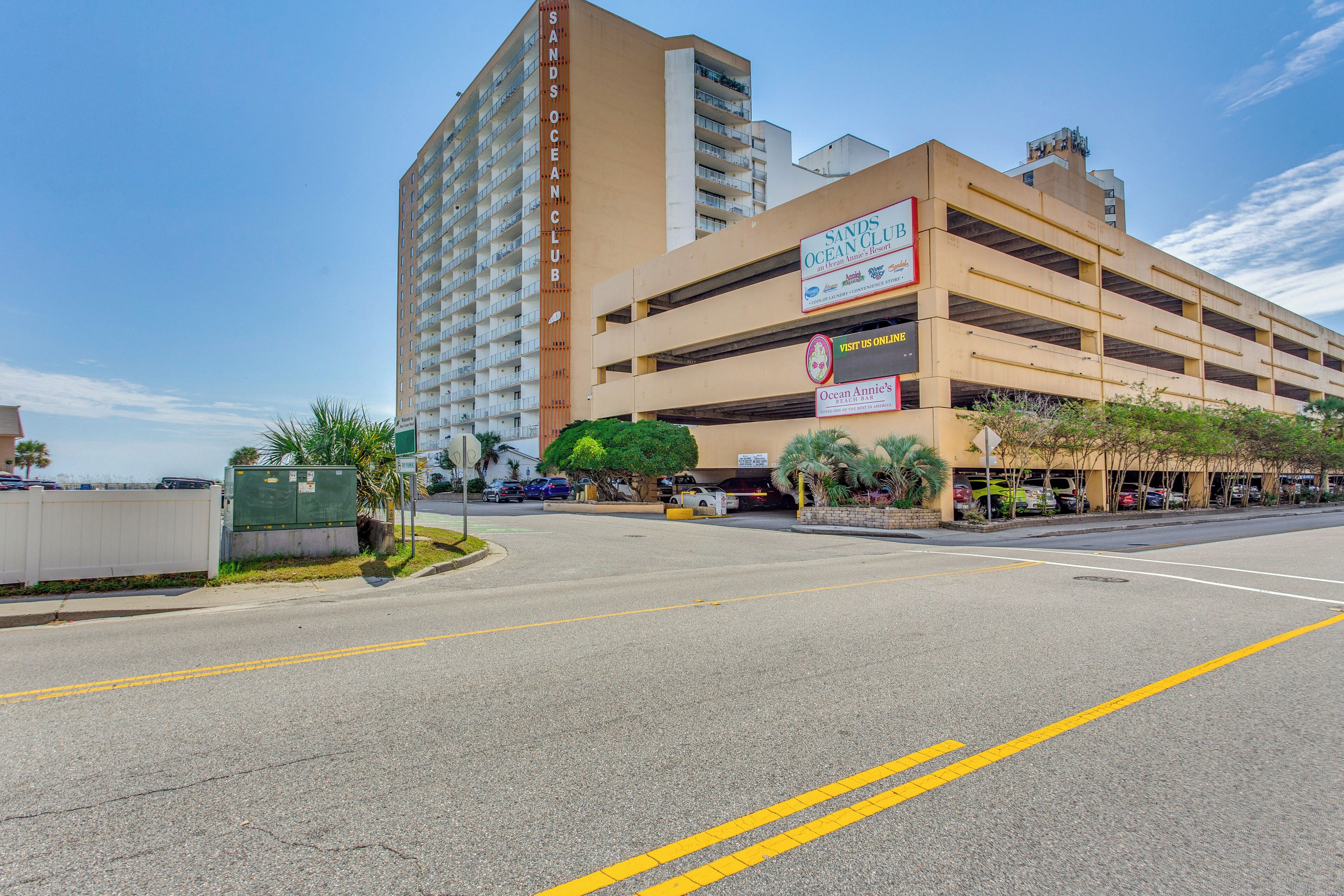 Een meerlaagse parkeergarage met een bord waarop 'Sands Ocean Club' en 'Ocean Annie's' staat.