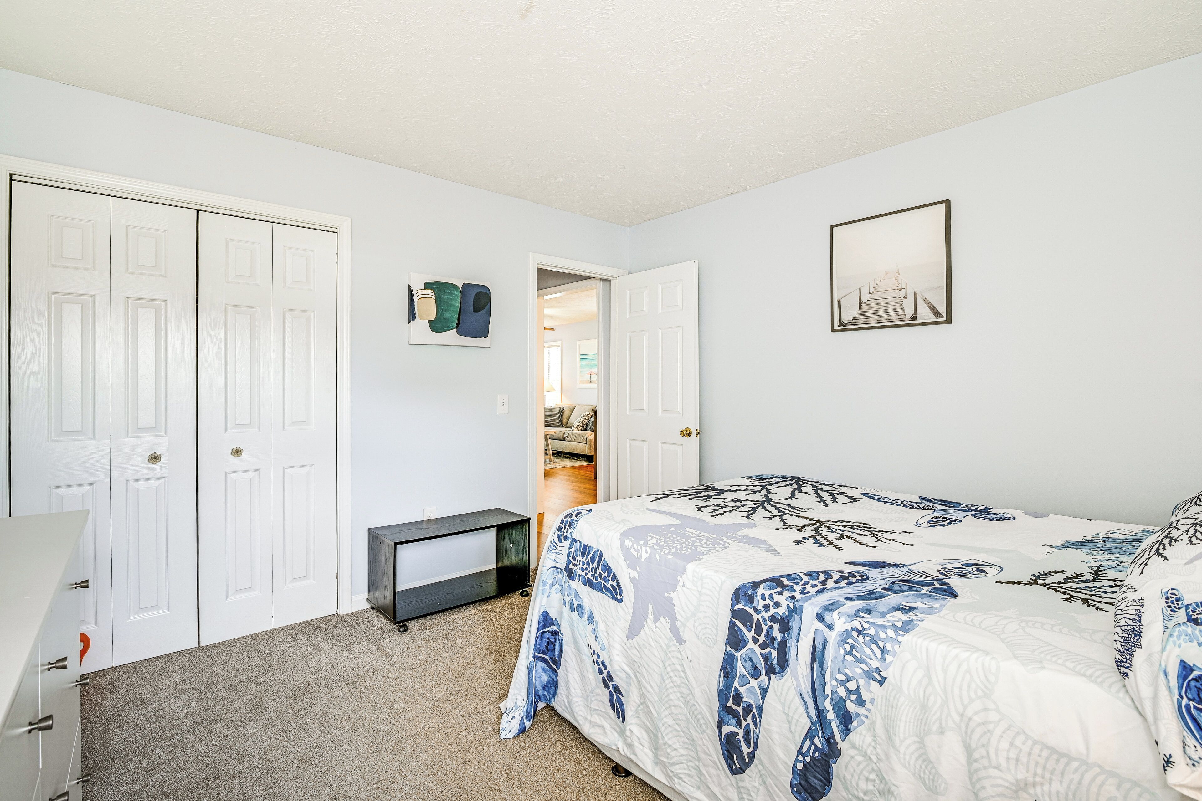 A bedroom with a bed, a desk, and a wardrobe.