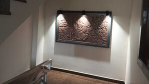 A staircase with a wall-mounted decorative panel featuring intricate carvings. - The Taj Mughal Courtyard Homestay (Agra)