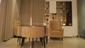 A modern living room with a round table, two armchairs, and a sofa. - The Taj Mughal Courtyard Homestay (Agra)