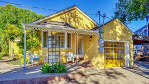 Una casa amarilla con porche, garaje y un pequeño jardín.