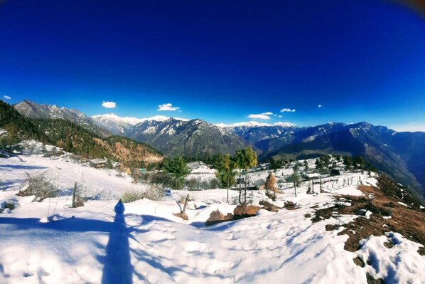 A panoramic view of a snow-covered mountain landscape with a clear sky.