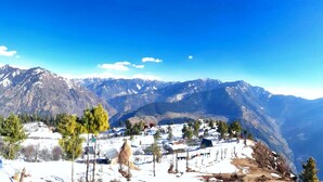 A mountainous landscape with a village nestled among the hills. - Vansh Green View Homestay (Sainj)