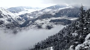 A mountainous landscape with snow-covered terrain and dense forests. - Vansh Green View Homestay (Sainj)