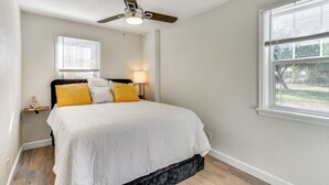 A bedroom with a bed, a ceiling fan, a window, and a nightstand with a lamp. - 4 Mi to Dtwn: Cozy Home in Pueblo (Pueblo)