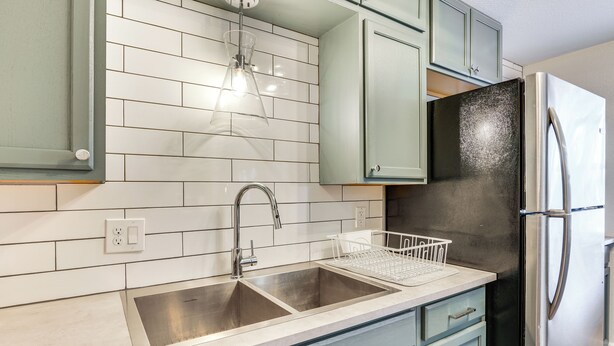 A kitchen with a double sink, stainless steel appliances, and light green cabinets. - 4 Mi to Dtwn: Cozy Home in Pueblo (Pueblo)