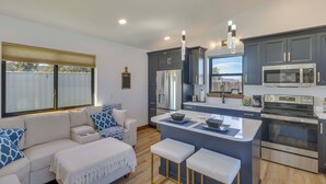 A modern kitchen with dark cabinets, a central island, and stainless steel appliances. - "montana Blue" w/ Grill Near Skiing! (Kalispell)