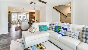 A modern living room with a white sectional sofa, a coffee table, and a ceiling fan. - 2 Mi to Hollywood Casino: Charles Town Townhome! (Charles Town)