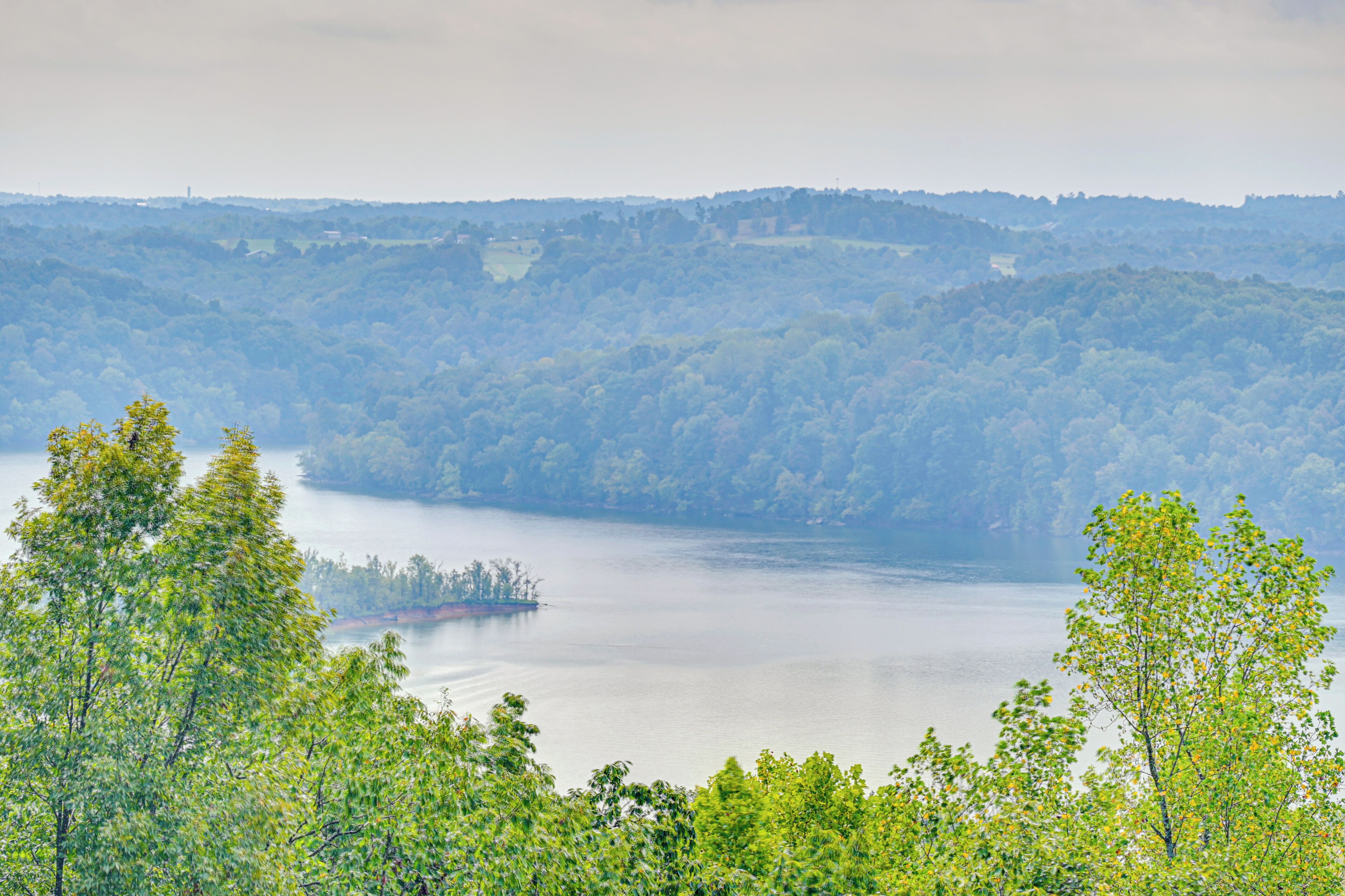 A lake surrounded by dense forest and hills.