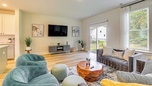 A modern living room with a sofa, ottomans, a coffee table, and a TV. - 13 Mi to Dtwn Charleston: Quiet Townhome (Hanahan)