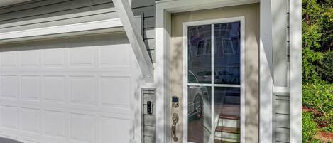 A garage door and a front door with a window.