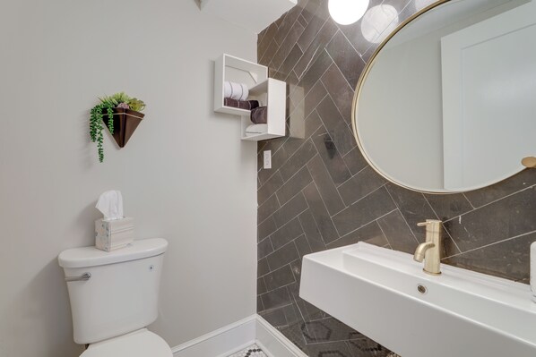 Ein Badezimmer mit Toilette, Waschbecken, Spiegel und Zierpflanzen.