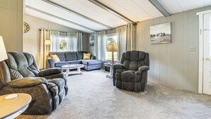 A spacious living room with a sectional sofa, a recliner, and a coffee table. - Lake Views & Fireside Bliss: Cecil Cottage w/ Yard (Cecil)