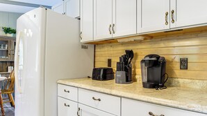 A kitchen with white cabinets, a white refrigerator, a wooden countertop, and a coffee maker. - Lake Views & Fireside Bliss: Cecil Cottage w/ Yard (Cecil)