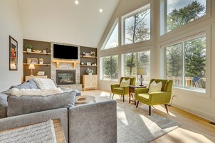 Un salón amplio con chimenea, ventanas grandes y una zona de estar acogedora.