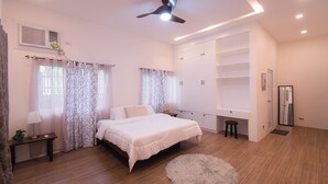 A bedroom with a bed, a desk, a wardrobe, and a ceiling fan. - GAVs Abode: Your Spacious and Peaceful home in Duma (Dumaguete)