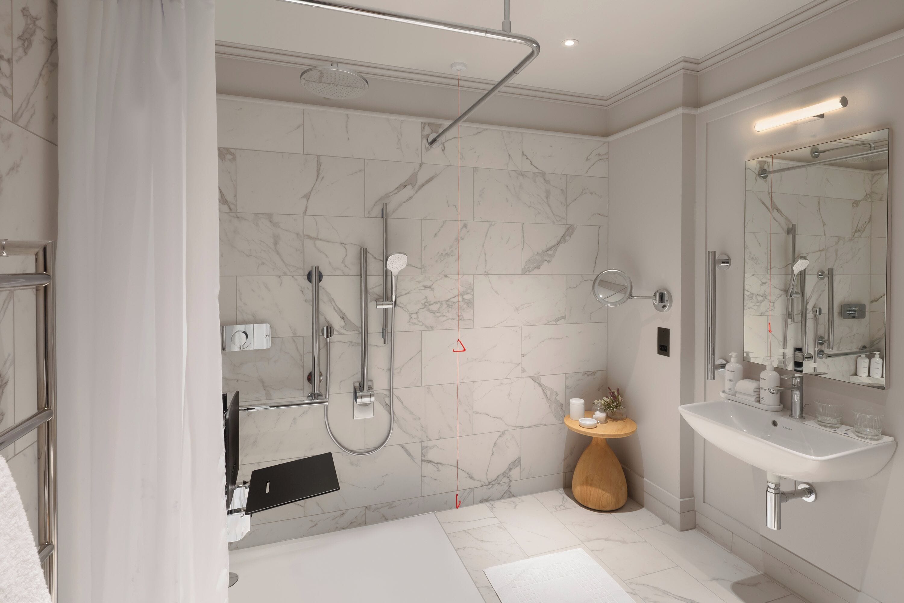 A modern bathroom with a shower, sink, and mirror.