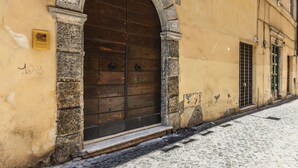 A building with a large wooden door, stone archway, and a cobblestone street.
