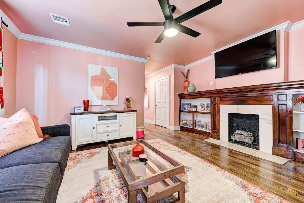 A living room with a sofa, coffee table, fireplace, and TV.