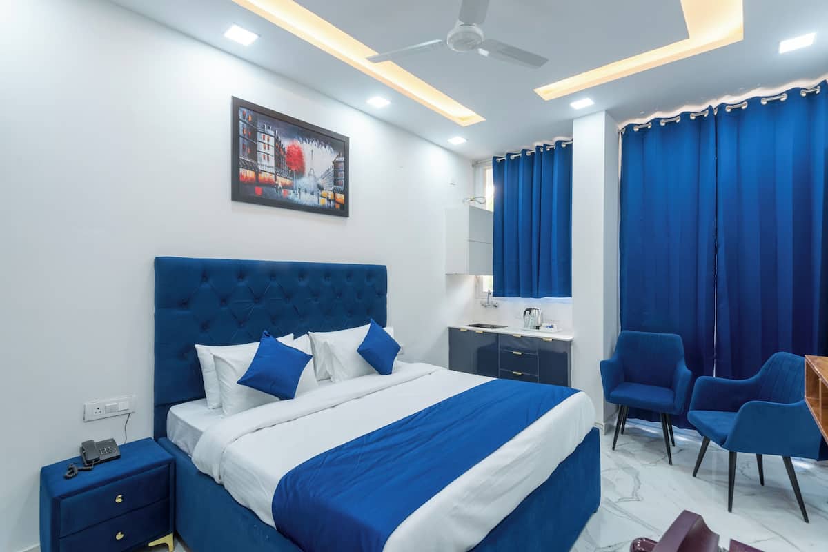 A modern hotel room with a large bed, a desk, and a chair.