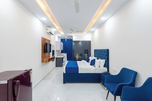 A modern hotel room with a large bed, a desk, a chair, and a TV. - Park Pacific By Saavi Hotel (Gurugram)