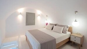 Ein Schlafzimmer mit einem Bett, Nachttischen und Wandleuchten.