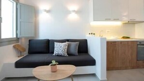 Un salon moderne avec un canapé, une petite table basse et une plante en pot.