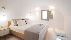 Un dormitorio con cama, mesitas de noche y una lámpara de pared.