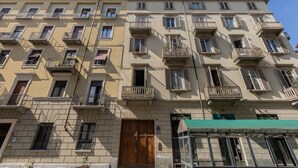 Un edificio de varios pisos con balcones, un toldo verde y un letrero que dice 'SAN SALVATOR'.