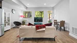 Una sala moderna con sofá, mesa de comedor y televisión.