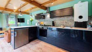 Een moderne keuken met een ingebouwde vaatwasser, roestvrijstalen apparatuur en een groot kookeiland.