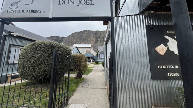 A hostel entrance with a sign reading "COMPLEJO DE CABANAS Don Joel HOSTEL & ALBERGUE". - Complejo Don Joel (El Chalten)