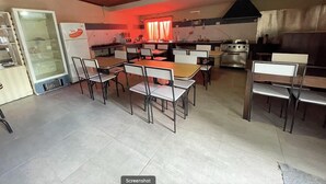 A spacious kitchen with modern appliances, a dining area with tables and chairs, and a large oven. - Complejo Don Joel (El Chalten)