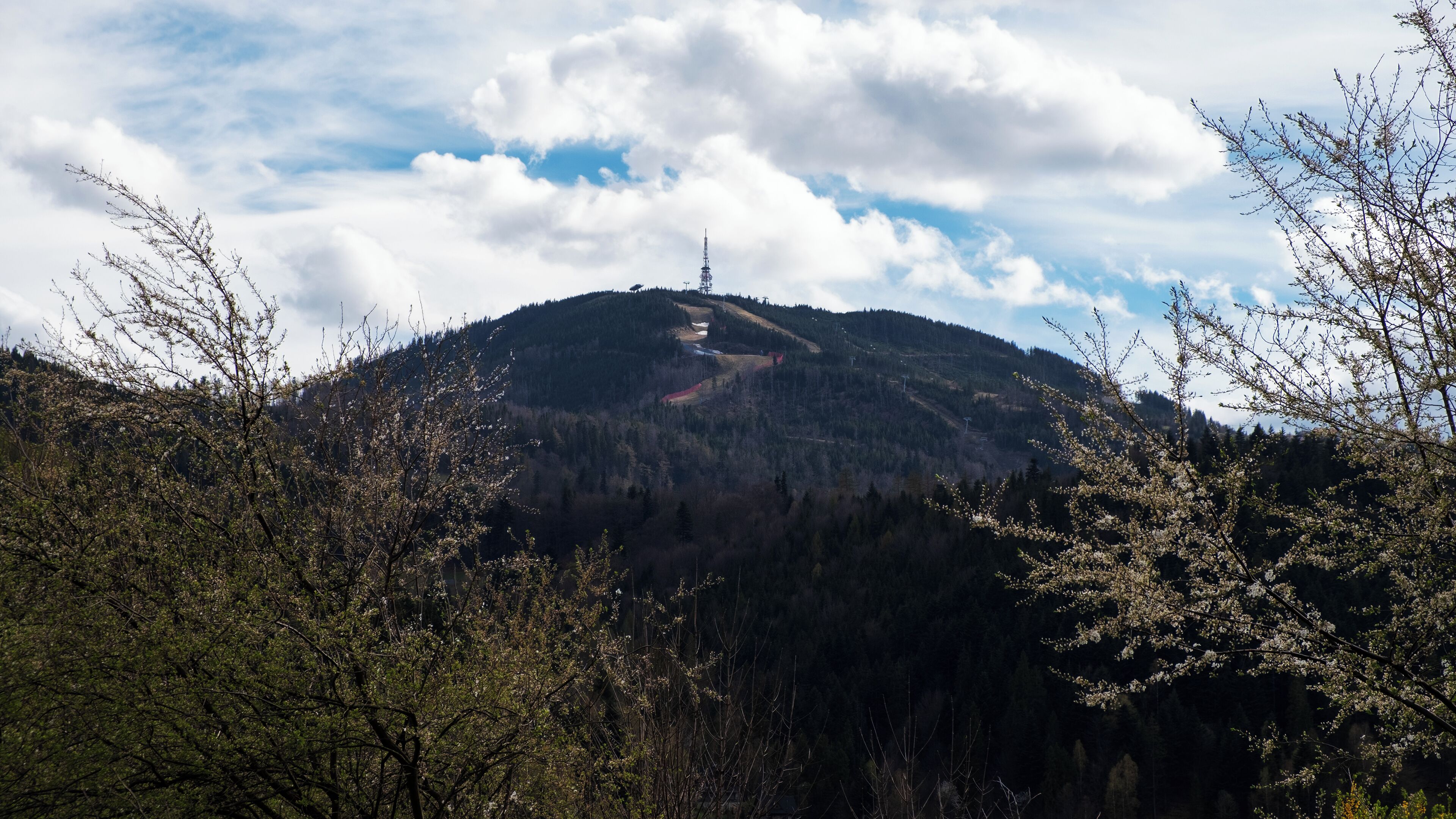 Un paysage de montagne avec une tour de télécommunications au sommet.