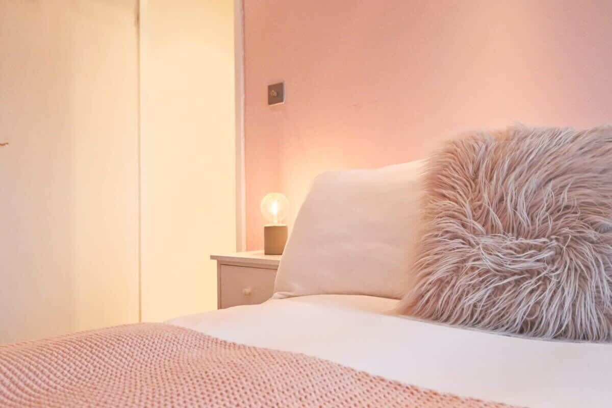 A bedroom with a bed, a nightstand, and a lamp.