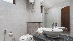 Un bagno moderno con il water, un lavandino ampio e una doccia.