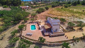 Eine Villa mit Swimmingpool, Sitzgelegenheit im Freien und Meerblick.