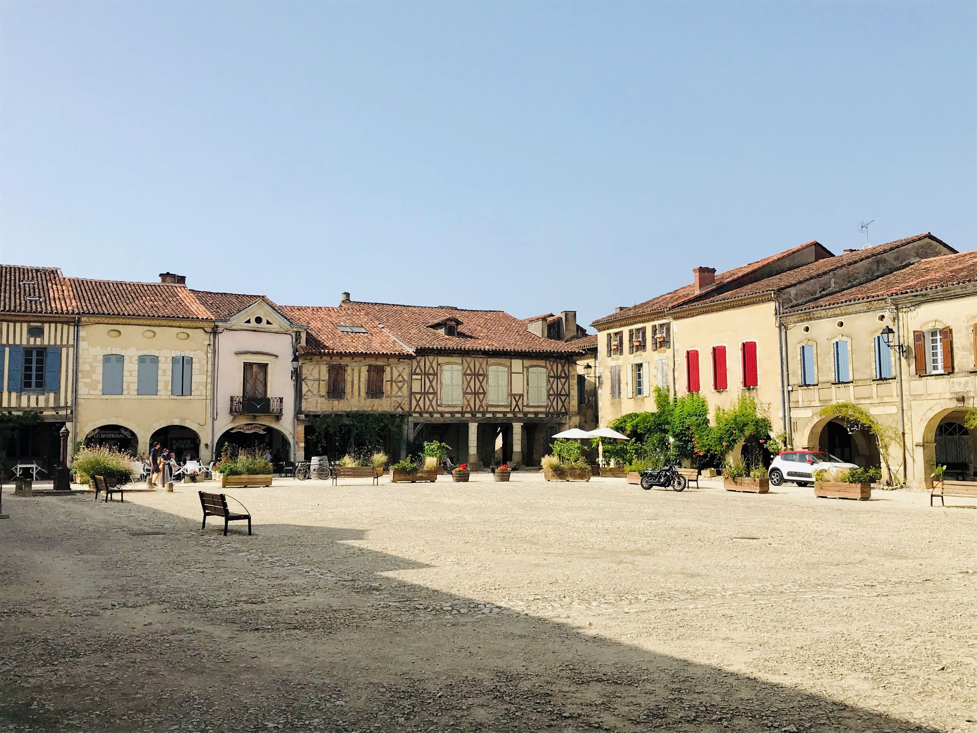 Ein Innenhof mit Gebäuden im traditionellen Stil, Bänken und einem Motorrad.