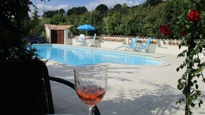 A swimming pool with lounge chairs and a glass of red wine on a table. - Rural gite in the beautiful Lot et Garonne with air con. Heated swimming pool. (Coulx)