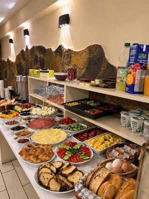 A buffet with various food items including meats, cheeses, fruits, and bread. - Taksim Dora Hotel (Istanbul)