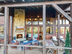 Eine rustikale Holzhütte mit Kamin aus Stein, einer Holzdiele und großen Fenstern.