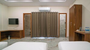 A hotel room with two beds, a TV, a wardrobe, and an air conditioning unit. - Hotel U Connect Near RTO Office, Udaipur (Udaipur)