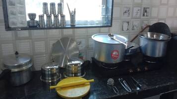 Uma cozinha com diversos utensílios de cozinha, panelas e uma janela com vista para o exterior.