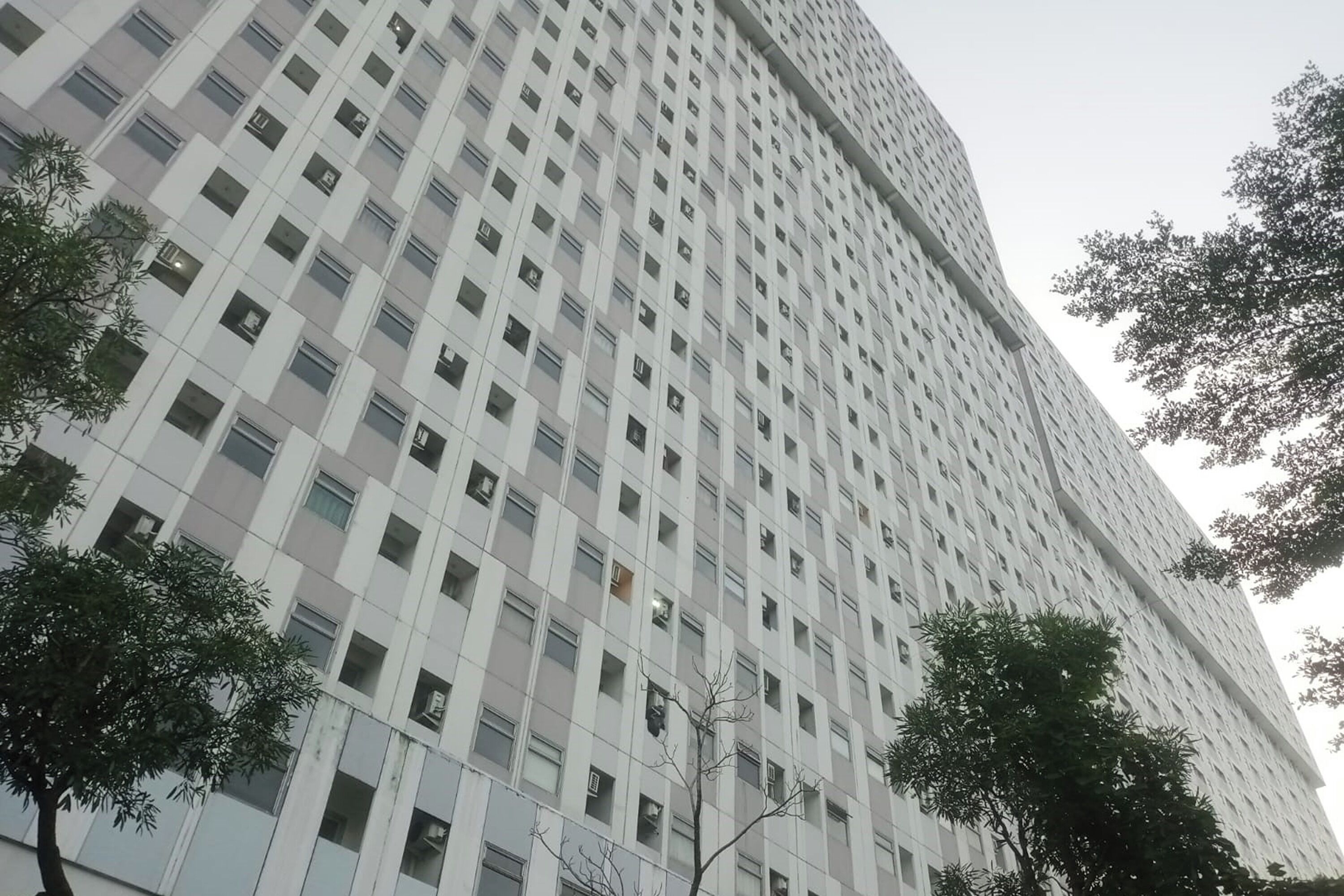 A tall, modern building with a grid of windows and balconies.