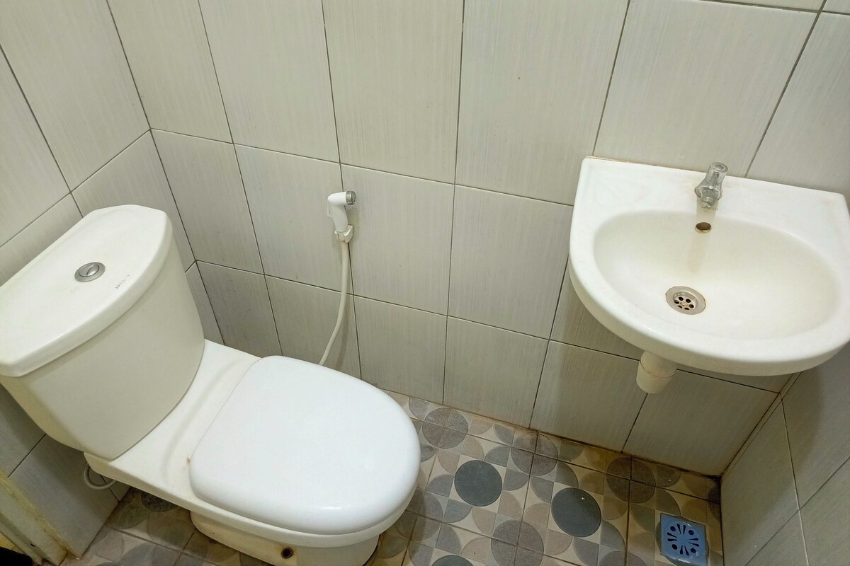 A bathroom with a toilet, a sink, and tiled walls.