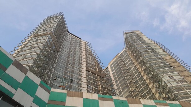 A high-rise building with a unique angular design and extensive scaffolding.