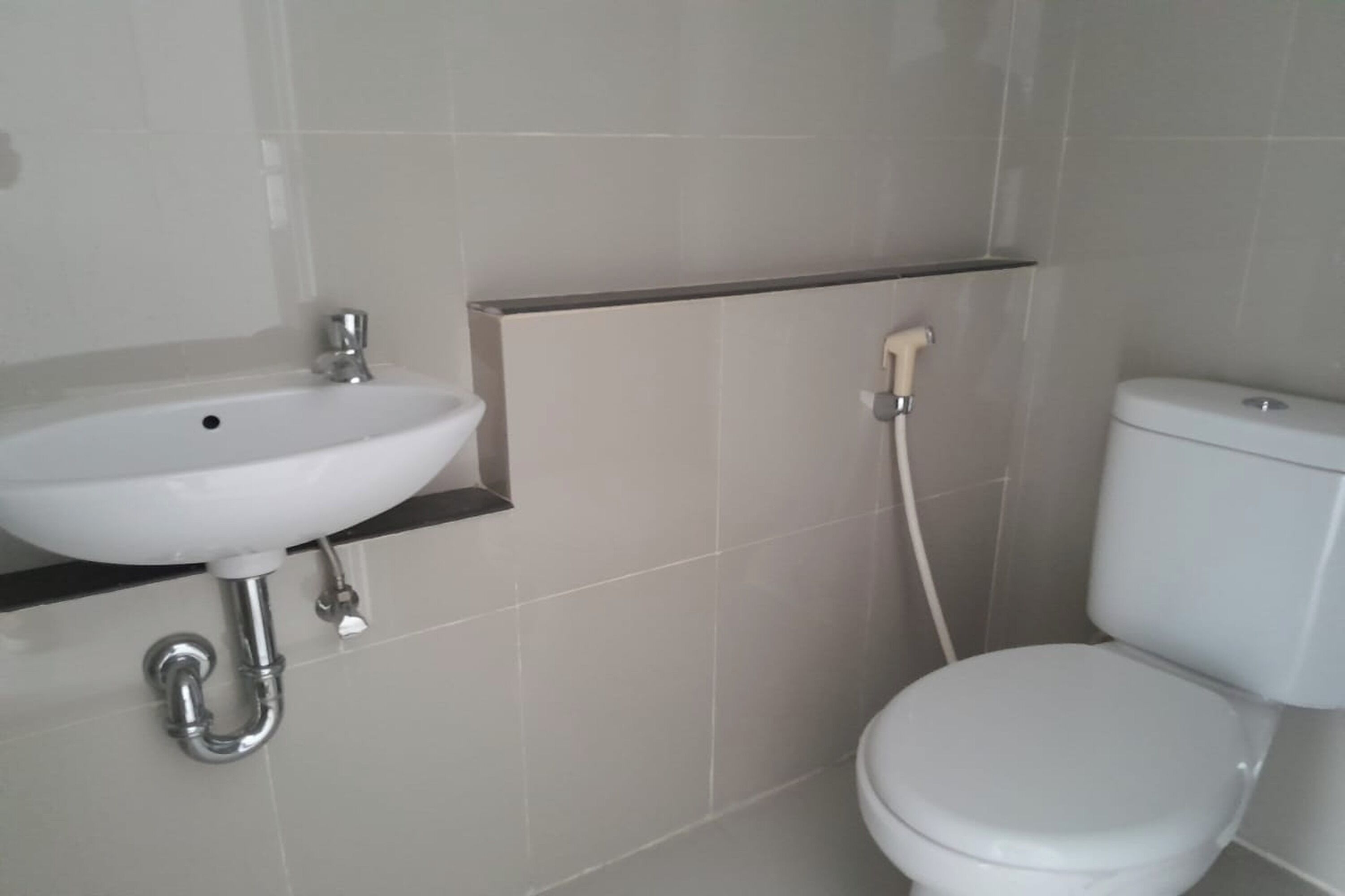 Ein Badezimmer mit weißem Waschbecken, WC und Dusche.