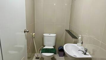 Un baño con inodoro, lavabo y ducha.