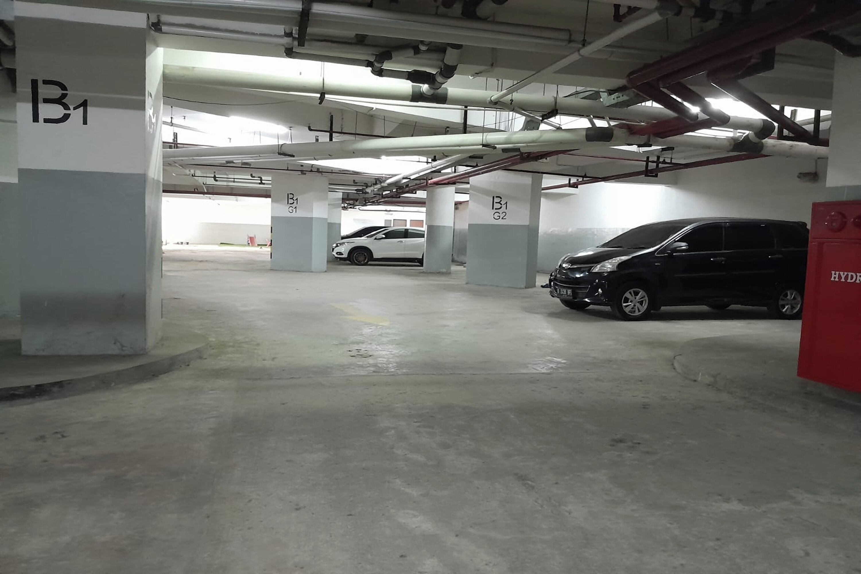 A multi-level parking garage with concrete pillars labeled B1 and G2.